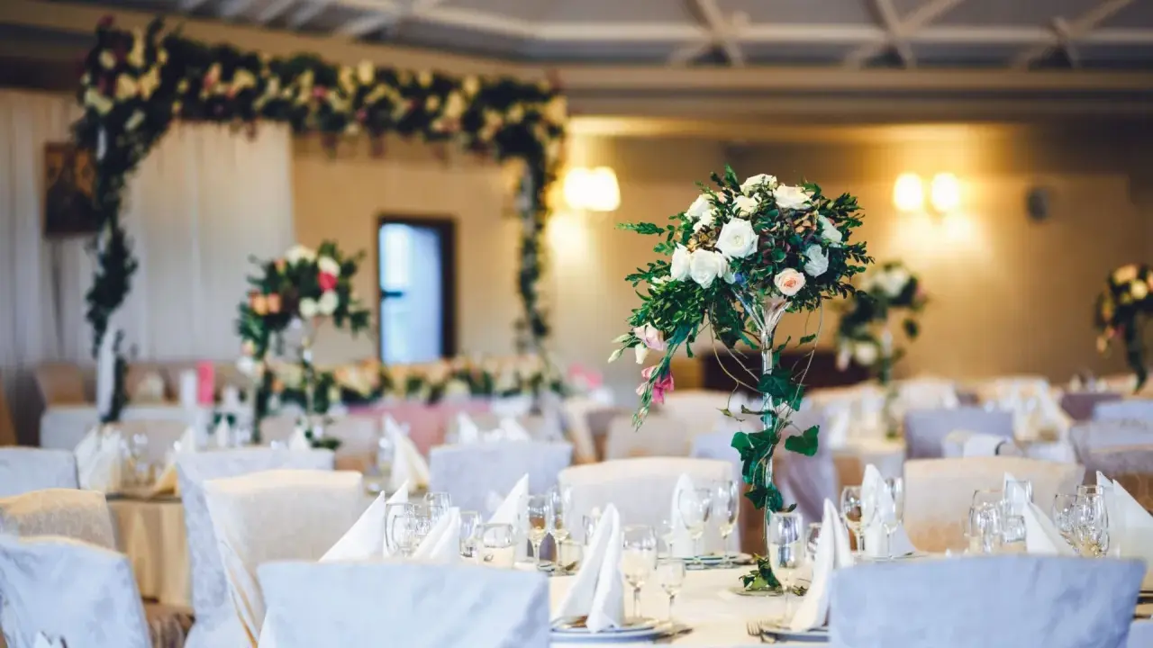 Eleganckie stoły z kwiatami i białymi obrusami, przygotowane na uroczysty ślub słowiański.