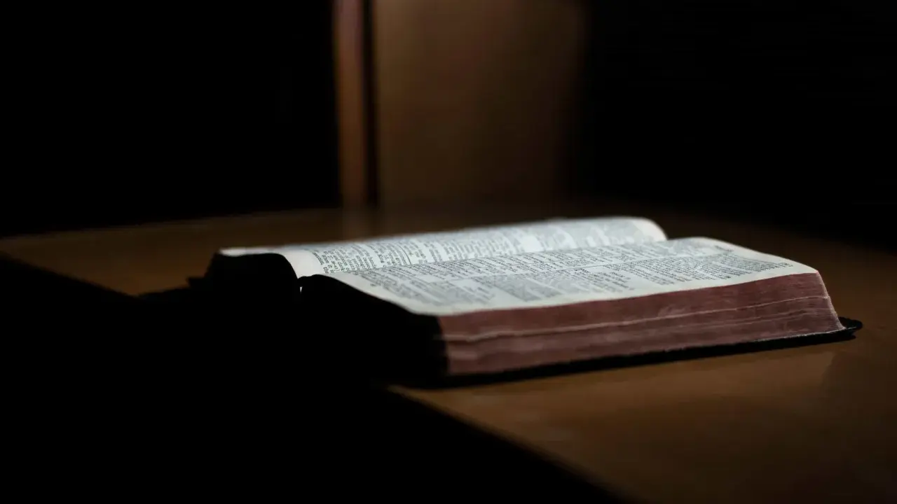 Otwarta Biblia na drewnianym stole, gotowa do modlitwy wiernych na ślub.