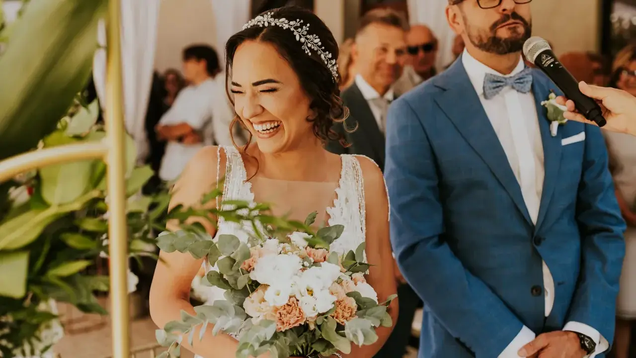 Szczęśliwa panna młoda z bukietem, pan młody w garniturze. Ceremonia ślubna cywilna, konsekwencje tej decyzji są radosne.