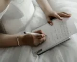 Panna młoda w białej sukni pisze list do przyszłego męża.