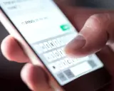 Palec pisze na klawiaturze telefonu: "Już w drodze". Potwierdzenie przybycia na wesele sms.