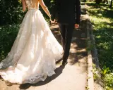 Para zjawiskowa suknia ślubna i elegancki garnitur idący ręka w rękę. Jak zareagować na zawiadomienie o ślubie?