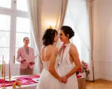 Dwie kobiety w białych sukniach ślubnych patrzą sobie w oczy podczas ceremonii. To piękny ślub homoseksualny.