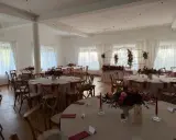 Elegancka sala weselna z okrągłymi stołami, kwiatami i świecami. Wesele co trzeba wiedzieć, by wszystko było idealne.