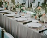 Eleganckie bukiety na stół weselny z goździków, róż i gipsówki, tworzą romantyczną atmosferę.