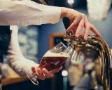 Barman nalewa piwo do kieliszka. Zastanawiasz się, ile piwa na poprawiny? To piwo wygląda pysznie!