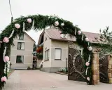 Piękna brama weselna z gałązek i różowych kwiatów, wspaniałe pomysły na ślubne dekoracje.