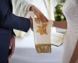 Ceremonia ślubna z kapłanem błogosławiącym ręce pary. Czy ślub kościelny ma moc prawną? To pytanie zadaje sobie wiele par.