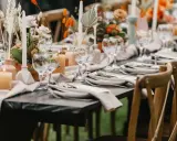 Eleganckie dekoracje stołów na przyjęcie: świece, kwiaty i szkło tworzą ciepłą atmosferę.