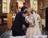 Para młoda całuje się w kościele podczas ślubu kanonicznego. Panna młoda w pięknej sukni, pan młody w garniturze.