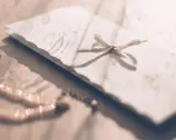 Delikatna biżuteria i zaproszenie z kokardką. Zastanawiasz się, kogo pierwszego wpisać na zaproszeniu?