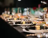 Elegancko nakryty stół weselny z kieliszkami i talerzykami. Zastanawiasz się, ile za talerzyk na wesele?