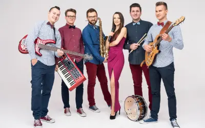 Zespół weselny gotowy do występu. Muzycy z gitarami, saksofonem, klawiszami, mikrofonem i perkusją. Idealni do odpowiedzi na pytania do zespołu weselnego.