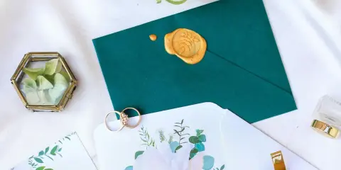 Elegancka koperta na wesele z pieczęcią, obrączki i ozdobne pudełeczko z suszonymi kwiatami.