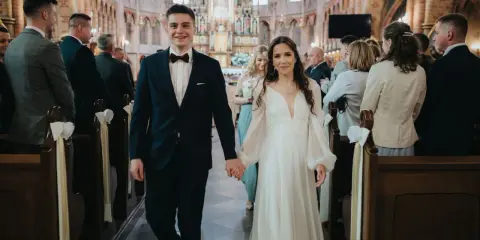 Para młoda idzie do ołtarza w kościele. To piękny ślub konkordatowy, pełen radości i miłości.