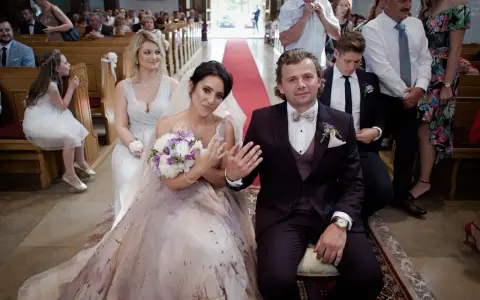 Para młoda podczas ceremonii zaślubin. Panna młoda w pięknej sukni, pan młody w garniturze.