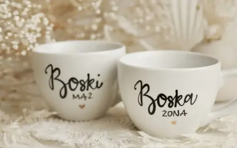 Dwie białe filiżanki z napisami "Boski Mąż" i "Boska Żona" - idealne co zamiast kwiatów na ślub cywilny.