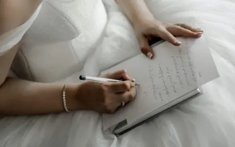 Panna młoda w białej sukni pisze list do przyszłego męża.