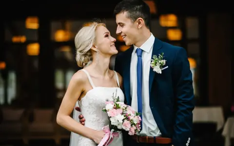 Para młoda, wzruszona, słucha pieśni na ślub na wejście. Bukiet w dłoni panny młodej.