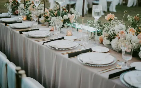 Eleganckie bukiety na stół weselny z goździków, róż i gipsówki, tworzą romantyczną atmosferę.