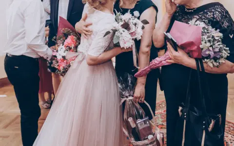 Wzruszający moment, gdy młoda para wręcza bukiety i kosz prezentów rodzicom. Może to część uroczystości, gdzie śpiewana jest oryginalna piosenka dla rodziców.