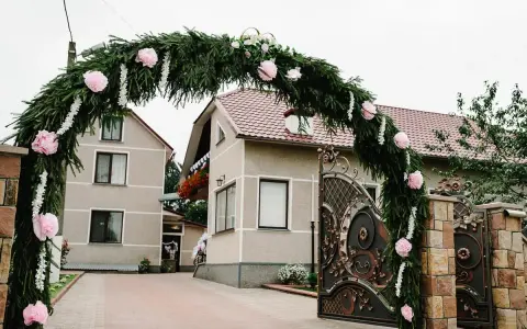 Piękna brama weselna z gałązek i różowych kwiatów, wspaniałe pomysły na ślubne dekoracje.