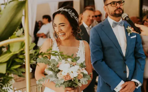 Szczęśliwa panna młoda z bukietem, pan młody w garniturze. Ceremonia ślubna cywilna, konsekwencje tej decyzji są radosne.