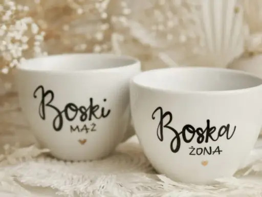 Dwie białe filiżanki z napisami "Boski Mąż" i "Boska Żona" - idealne co zamiast kwiatów na ślub cywilny.