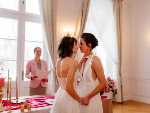 Dwie kobiety w białych sukniach ślubnych patrzą sobie w oczy podczas ceremonii. To piękny ślub homoseksualny.