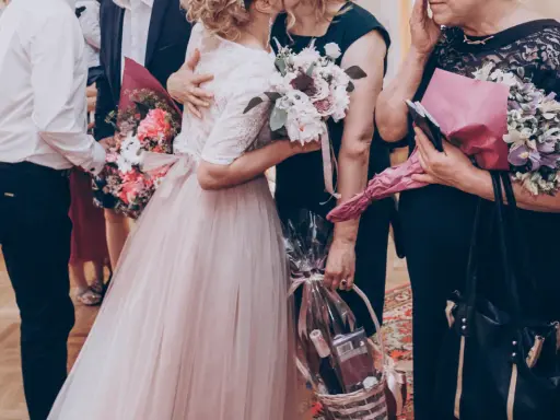 Wzruszający moment, gdy młoda para wręcza bukiety i kosz prezentów rodzicom. Może to część uroczystości, gdzie śpiewana jest oryginalna piosenka dla rodziców.