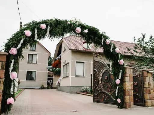 Piękna brama weselna z gałązek i różowych kwiatów, wspaniałe pomysły na ślubne dekoracje.