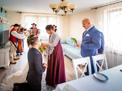 Wzruszający moment błogosławieństwa matki chrzestnej dla pary młodej, przy akompaniamencie kapeli góralskiej.