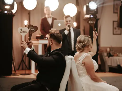 Para zabawy podczas wesela. Ona trzyma tabliczkę "Żona", on "Mąż". Prowadzący zadaje pytania w ramach testu małżeńskiego.