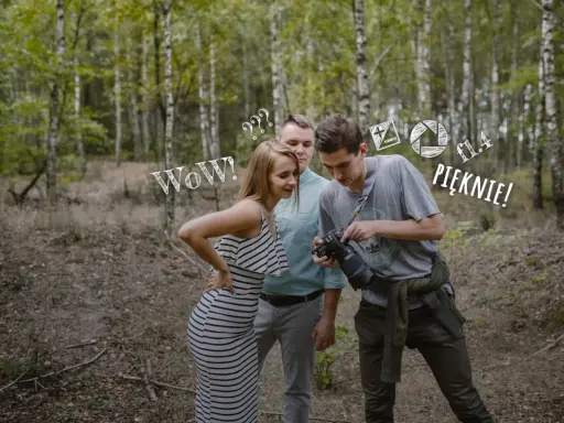 Para zapytań do fotografa ślubnego w lesie. Ona zachwycona, on pokazuje efekt.
