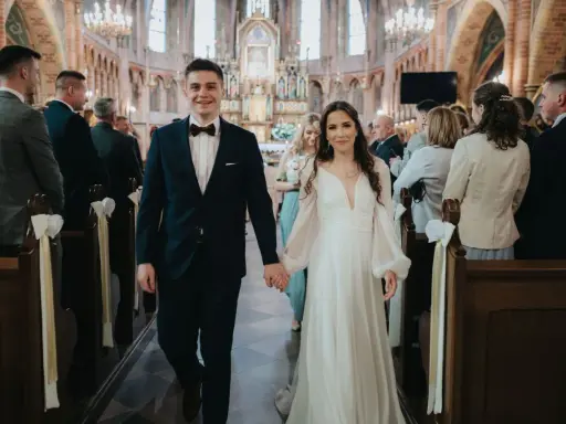 Para młoda idzie do ołtarza w kościele. To piękny ślub konkordatowy, pełen radości i miłości.