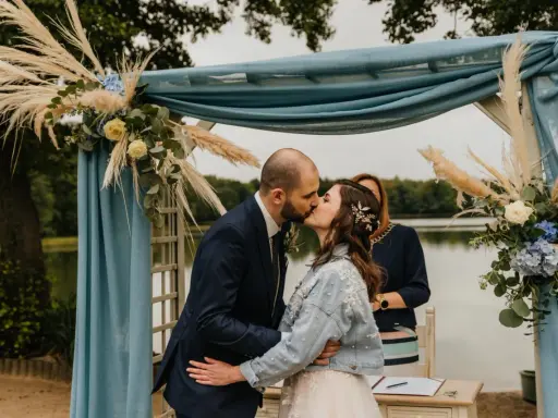 Para młoda całuje się pod błękitną altaną. To ich ślub bez wesela, kameralna ceremonia nad jeziorem.