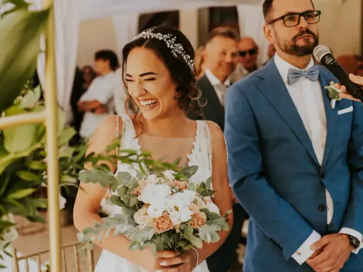 Szczęśliwa panna młoda z bukietem, pan młody w garniturze. Ceremonia ślubna cywilna, konsekwencje tej decyzji są radosne.