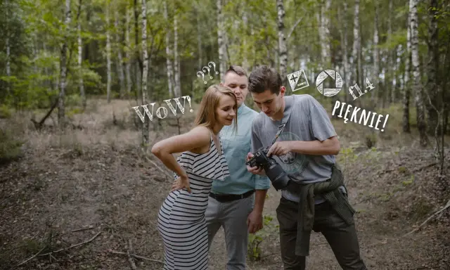 Para zapytań do fotografa ślubnego w lesie. Ona zachwycona, on pokazuje efekt.