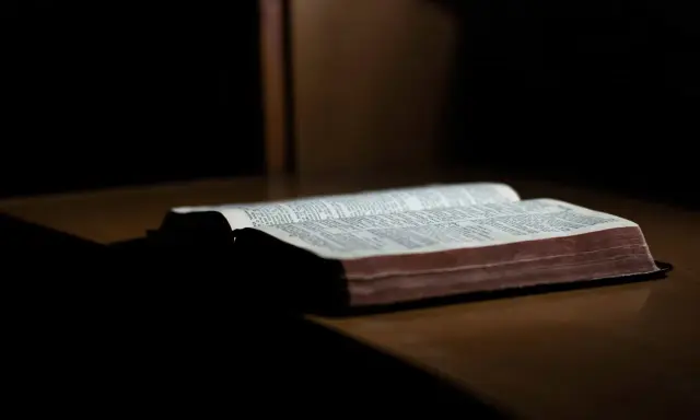 Otwarta Biblia na drewnianym stole, gotowa do modlitwy wiernych na ślub.