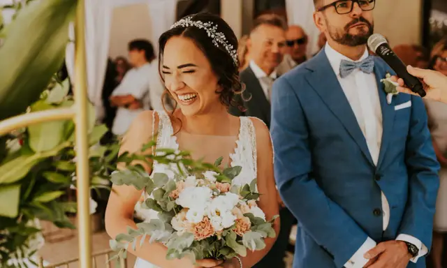 Szczęśliwa panna młoda z bukietem, pan młody w garniturze. Ceremonia ślubna cywilna, konsekwencje tej decyzji są radosne.