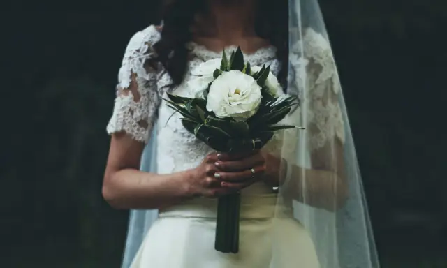 Panna młoda z bukietem białych róż, w welonie i koronkowej sukni. W myślach słyszy "Ave Maria po polsku na ślub tekst".