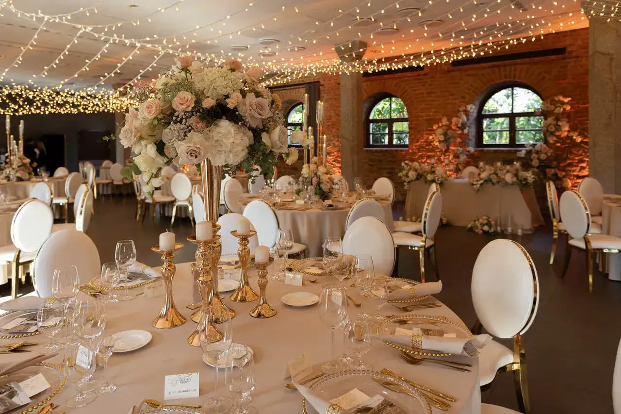 Eleganckie wesele na 60 osób. Złote świeczniki, bukiety róż i światełka tworzą magiczną atmosferę.