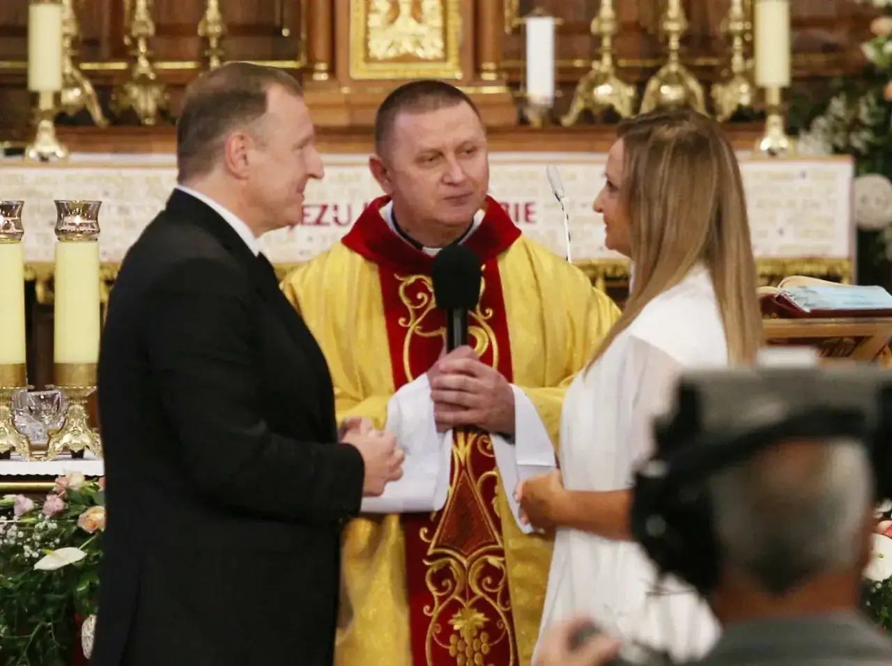 Uroczystość unieważnienia małżeństwa bez świadków. Ksiądz w szatach liturgicznych błogosławi parę w kościele.
