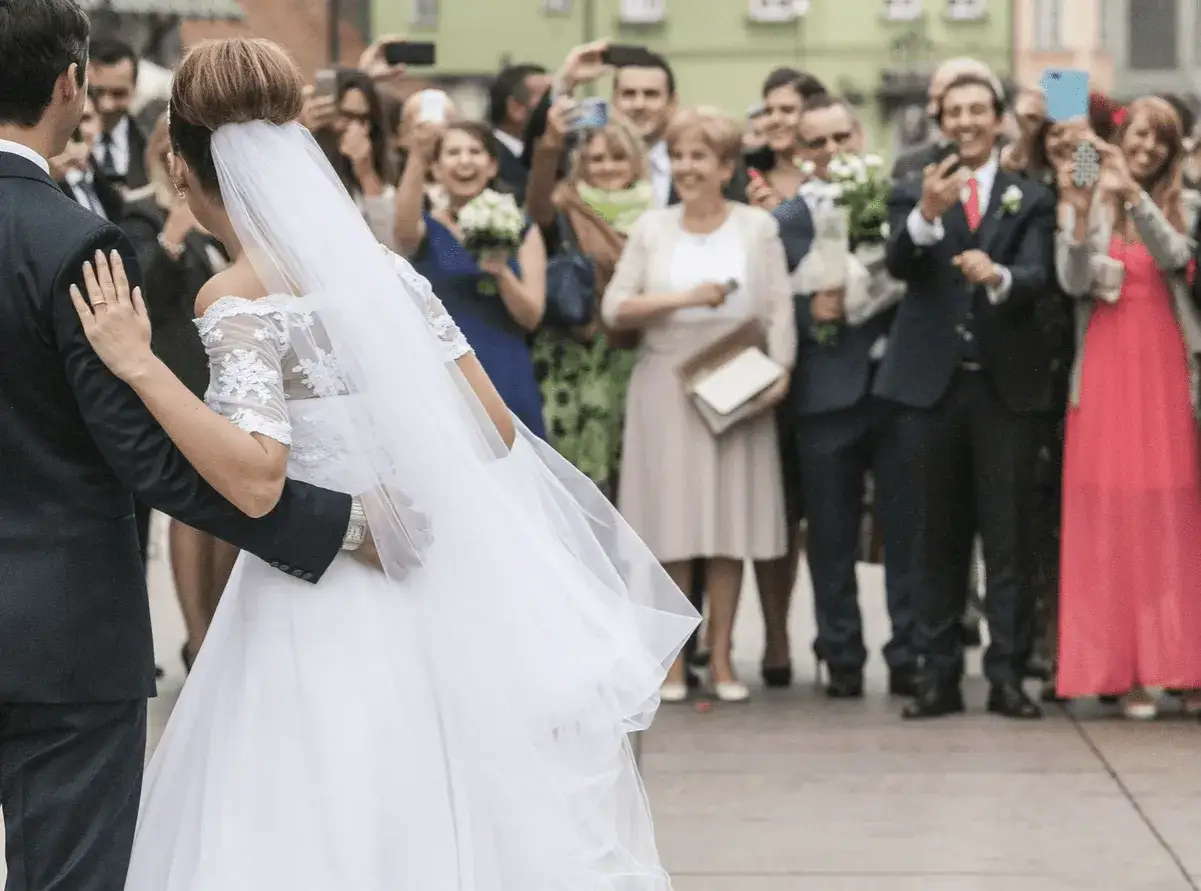 Para młoda idzie wśród gości, którzy robią zdjęcia. Wszyscy cieszą się tym radosnym piątek dyspensa.