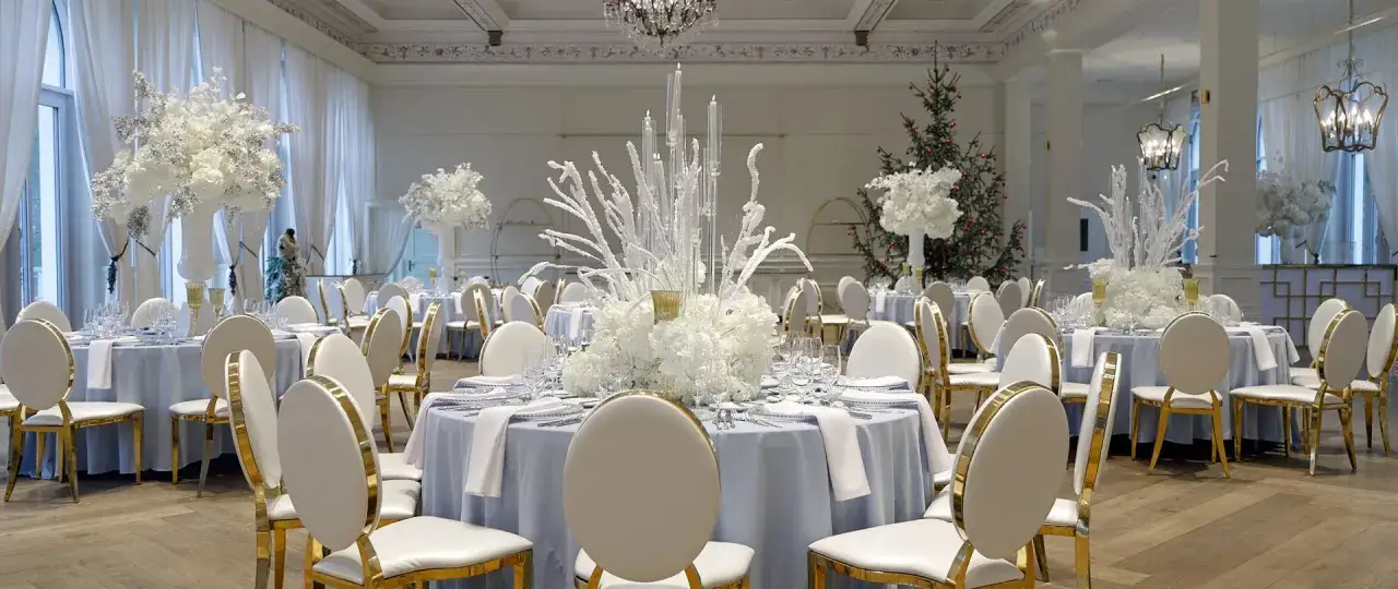 Elegancka sala weselna z białymi kwiatami i świecami. Choć grudzień może wydawać się najgorszy miesiąc na ślub, ta zimowa sceneria jest zachwycająca.