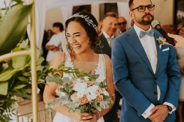 Szczęśliwa panna młoda z bukietem, pan młody w garniturze. Ceremonia ślubna cywilna, konsekwencje tej decyzji są radosne.